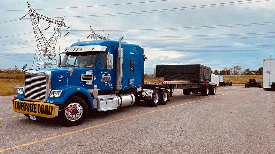 Oversize Shipment With Tarps on Trailer in Parking Lot